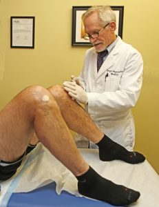 Dr. Noel Peterson demonstrating stem cell results for patient with knee OA