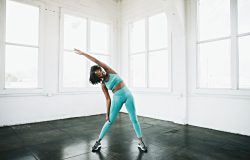 Woman stretching while experiencing menopause-related joint pain and connective tissue changes